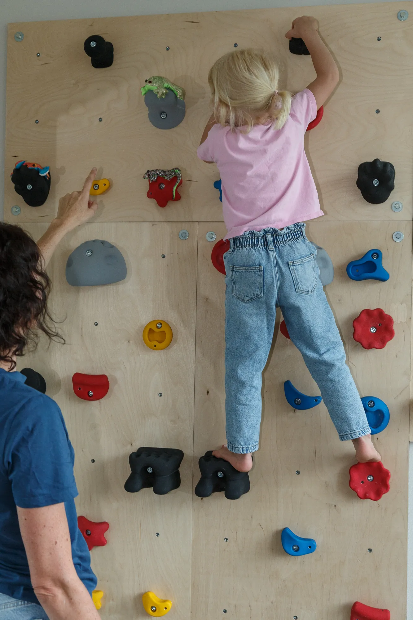 Kind klettert an der Boulderwand