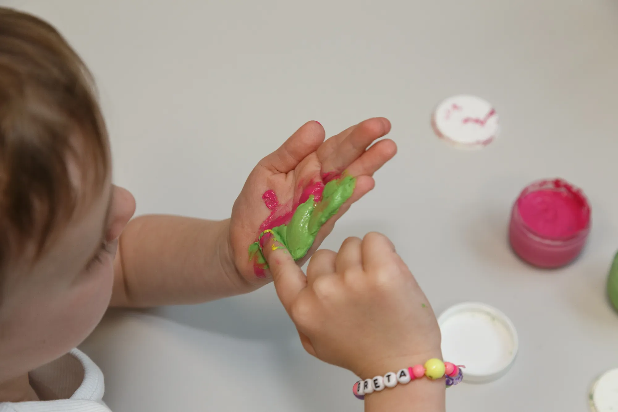 Kind erkundet Fingerfarben